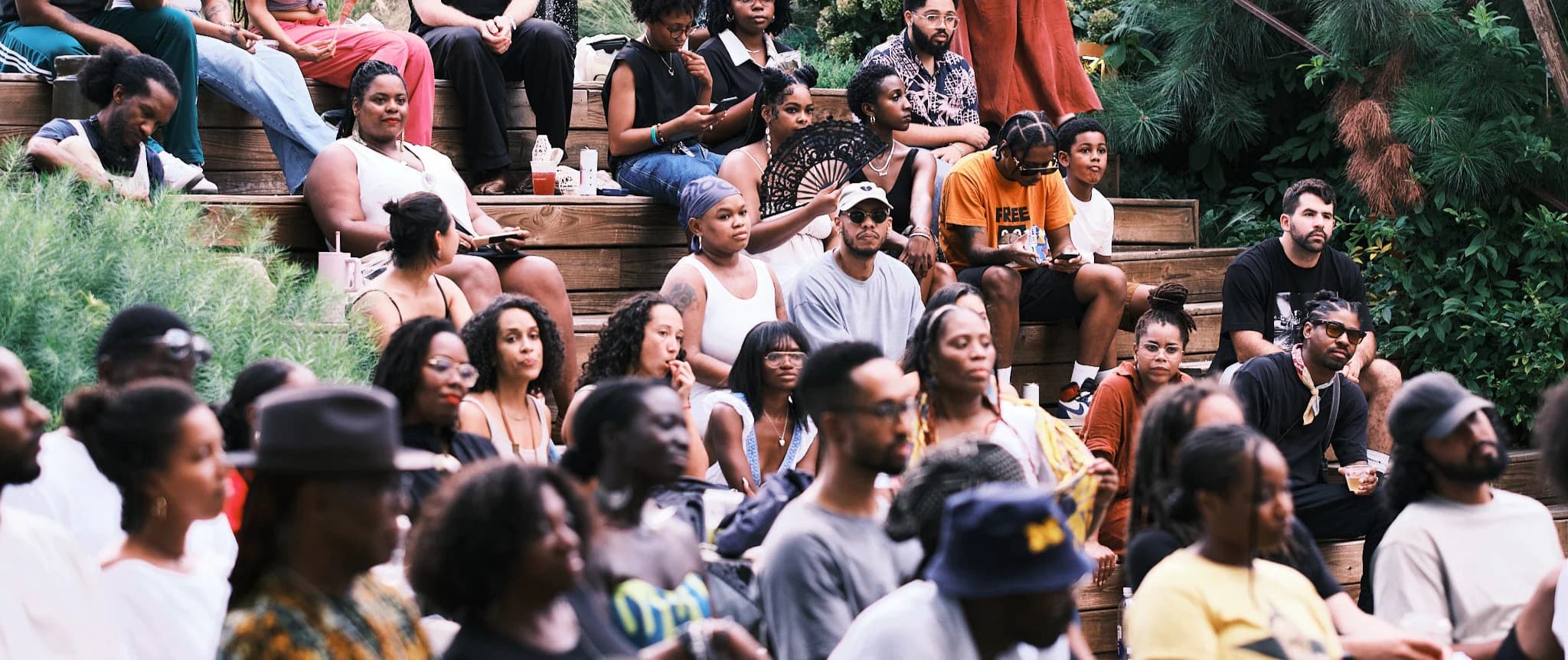 Crowd of people sitting on wooden bleachers